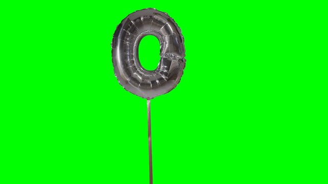 Letter O from alphabet helium silver balloon floating on green screen