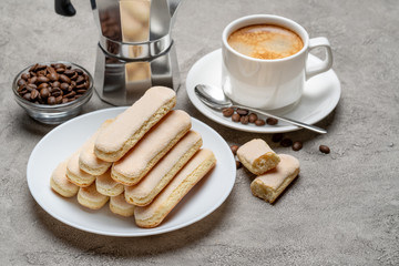 Italian Savoiardi ladyfingers Biscuits and cup of coffee on concrete backgound