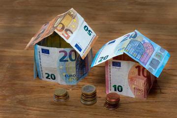 Deux maisons faites en billets de 10, 20, et 50 euros, avec quelques pièces de monnaie - obrazy, fototapety, plakaty