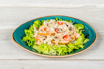 Salad with chicken, cheese, mushrooms, cheese on a white background