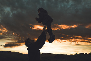 Father throwing his son into the air. Concept of happiness and joy between dad and child