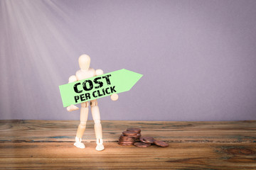 Cost Per Click concept. Wooden man with green an arrow
