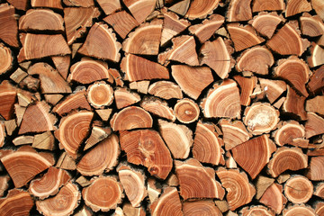 Background from sawn logs and firewood. A wall of wooded firewood