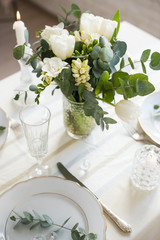 Beautiful festive table setting with elegant white flowers and cutlery, dinner table decoration 
