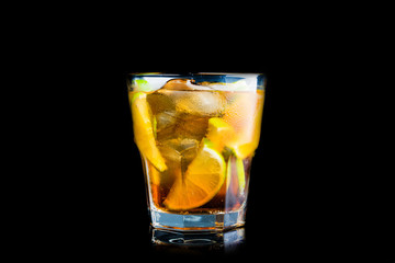 Cuba libre cocktail with cola and lime isolated on black background. Selective focus.