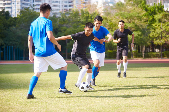 Asian Soccer Players Playing On Field