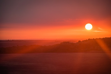 Fototapeta premium Stunning red sunset with gigantic sun in Brittany, France