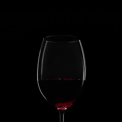 Silhouette of glass of red wine on black background. Close-up studio shot.
