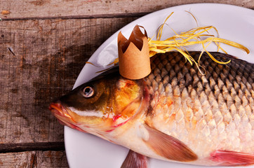 crucian carp  With a crown on wooden table. creative concept. King of fish