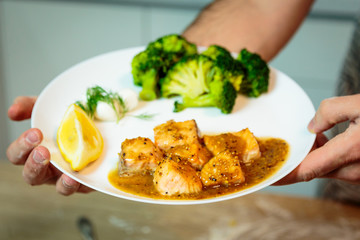 Salmon in sauce with broccoli  on a plate