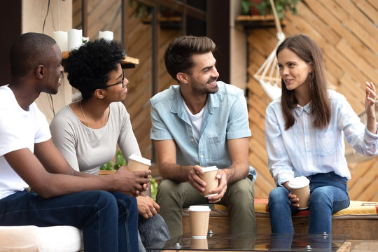 Friend listening to girl sitting together in cafe drinking coffee
