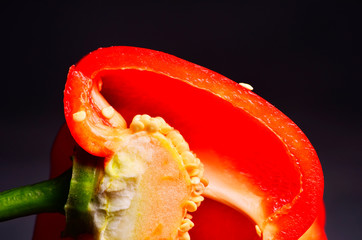 sweet red pepper and half cut isolated on black
