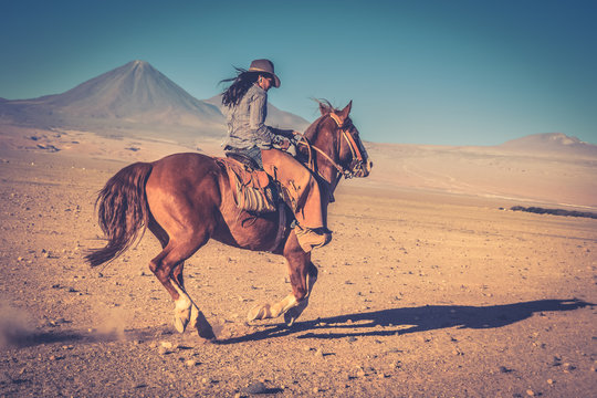 cowgirl woman riding a horse in the desert
