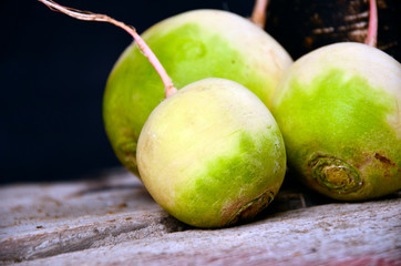 Black and white radish on round wooden kitchen board. Fresh, raw, healthy vegetable eating.