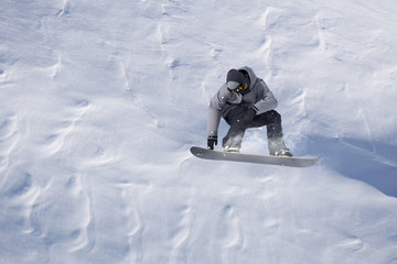 Snowboarder flying on the background of snowy slope. Extreme winter sports, snowboarding. Copy...