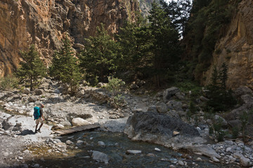 Crossing over mountain river at rocky terrain of Samaria gorge, south west part of Crete island, Greece