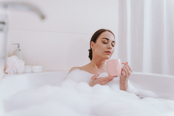 Nice delighted woman enjoying time in the bathroom