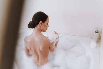 Pleasant young woman using her washcloth in the bathroom