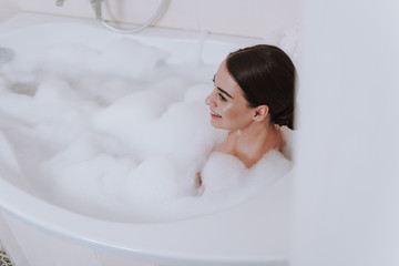 Cheerful attractive woman enjoying foam bath on the weekend