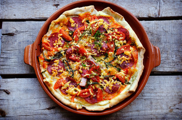 pizza with bacon, salami and vegetables