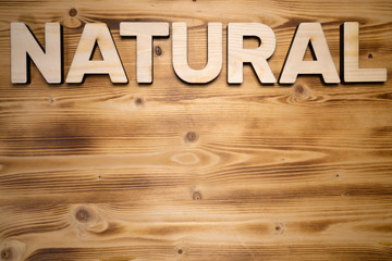 NATURAL word made with building blocks on wooden board.