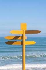 Yellow signpost near ocean