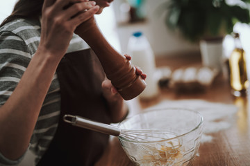Lady is cooking dish with spices at home