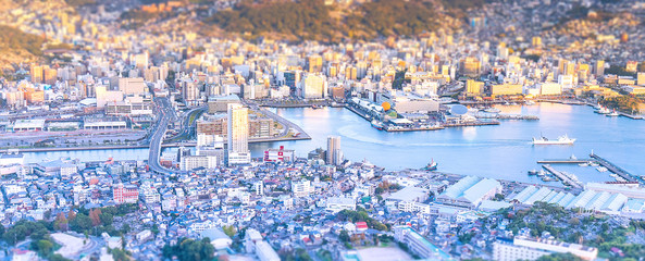 Business concept, tilt shift effect modern cityscape of nagasaki dusk from mount inasa, the new top 3 nightview of the world, aerial view, copy space - obrazy, fototapety, plakaty