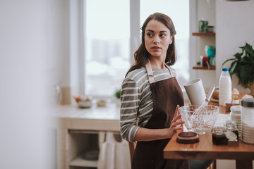 Young pretty housewife is cooking at home