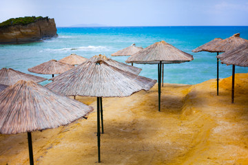 Beach at sea with canyon and sandy beach. Plastic seats on the sandy beach. Holiday concept with beach and sea in the background