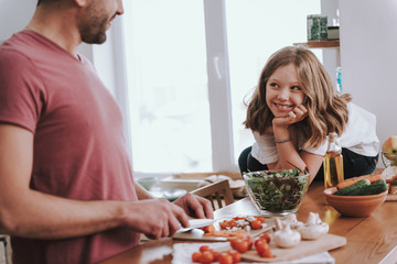 Adorable little girl spending time with father in kitchen