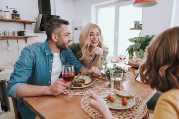 Happy parents having dinner with their daughter at home