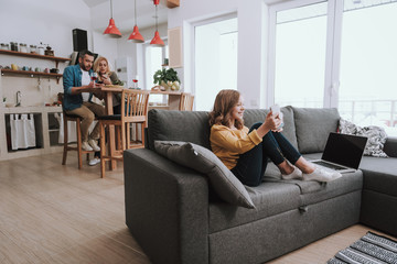 Family spending time at home and using smartphones