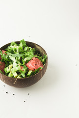 healthy green vegan salad in coconut bowl