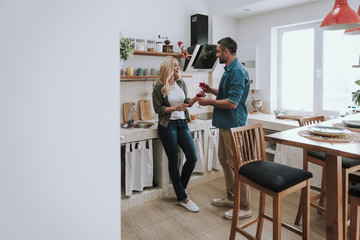 Beautiful loving couple drinking red wine at home