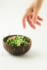 healthy green vegan salad in coconut bowl