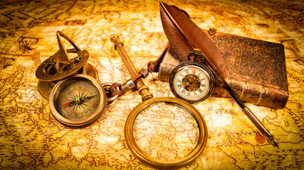 Vintage magnifying glass, pen, book, compass, pocket watch. Map of the Ancient World in 1565.