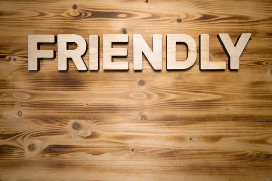 FRIENDLY word made with building blocks on wooden board.