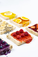 Delicious colourful minimal mix fruits jam on sliced bread. Set on white background.