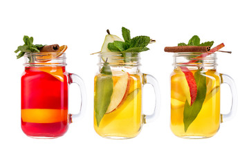 Three lemonade on a white background. Refreshing fruit and berry drinks in glass decanters.