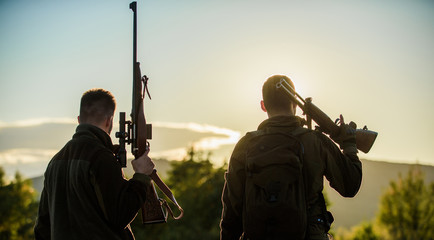 Hunters friends enjoy leisure. Hunters friends gamekeepers with guns silhouette sky background....