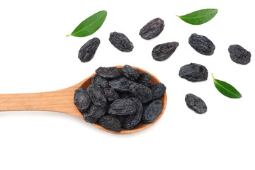 black raisins in wooden spoon with green leaves isolated on white background. top view