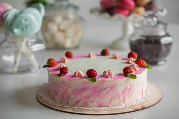 pink cake with berries on a white table