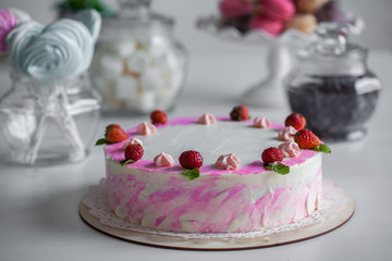 pink cake with berries on a white table