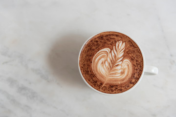 mocha coffee with frothy foam, top view on table in cafe.