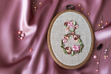 8th March symbol. Embroidery with satin ribbons figure of 