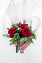 Bouquet of flowers on a white background. Wedding bouquet in hand. Floristic. Minimalistic designer bouquet in winter style. Beautiful composition of roses and coniferous branches