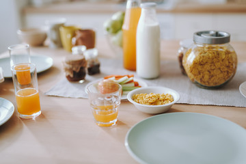 Corn flakes and orange juice on the kitchen table