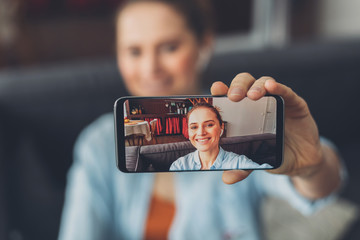Portrait of happy young lady in smartphone