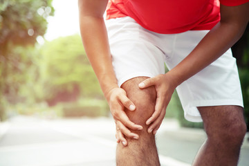 Runner touching painful twisted or broken ankle. Athlete runner training accident. Sport running ankle sprained sprain cause injury knee. and pain with leg bones.  Focus legs on to show pain. 